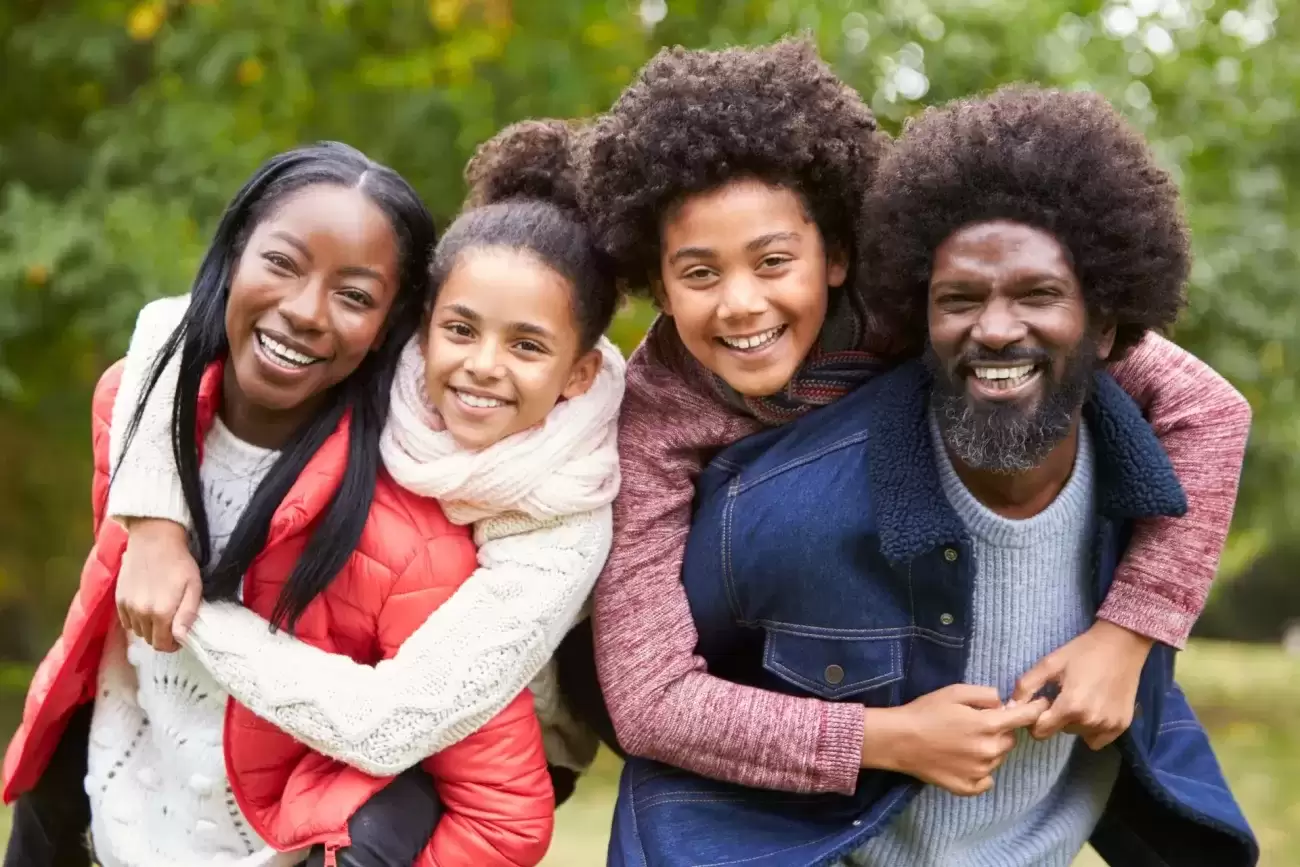 Foster family with kids on parents shoulders