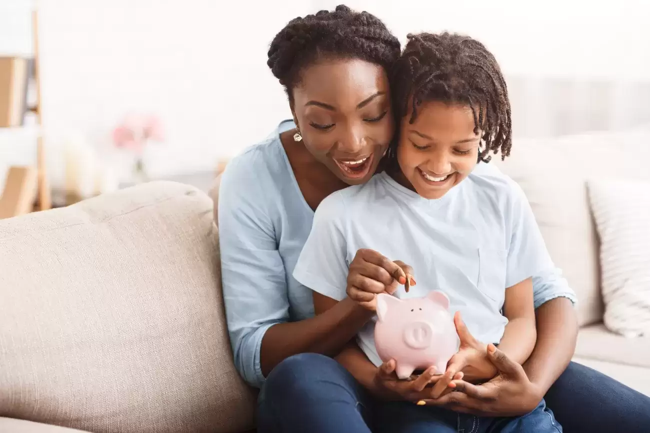 foster mom and child putting money in piggy bank