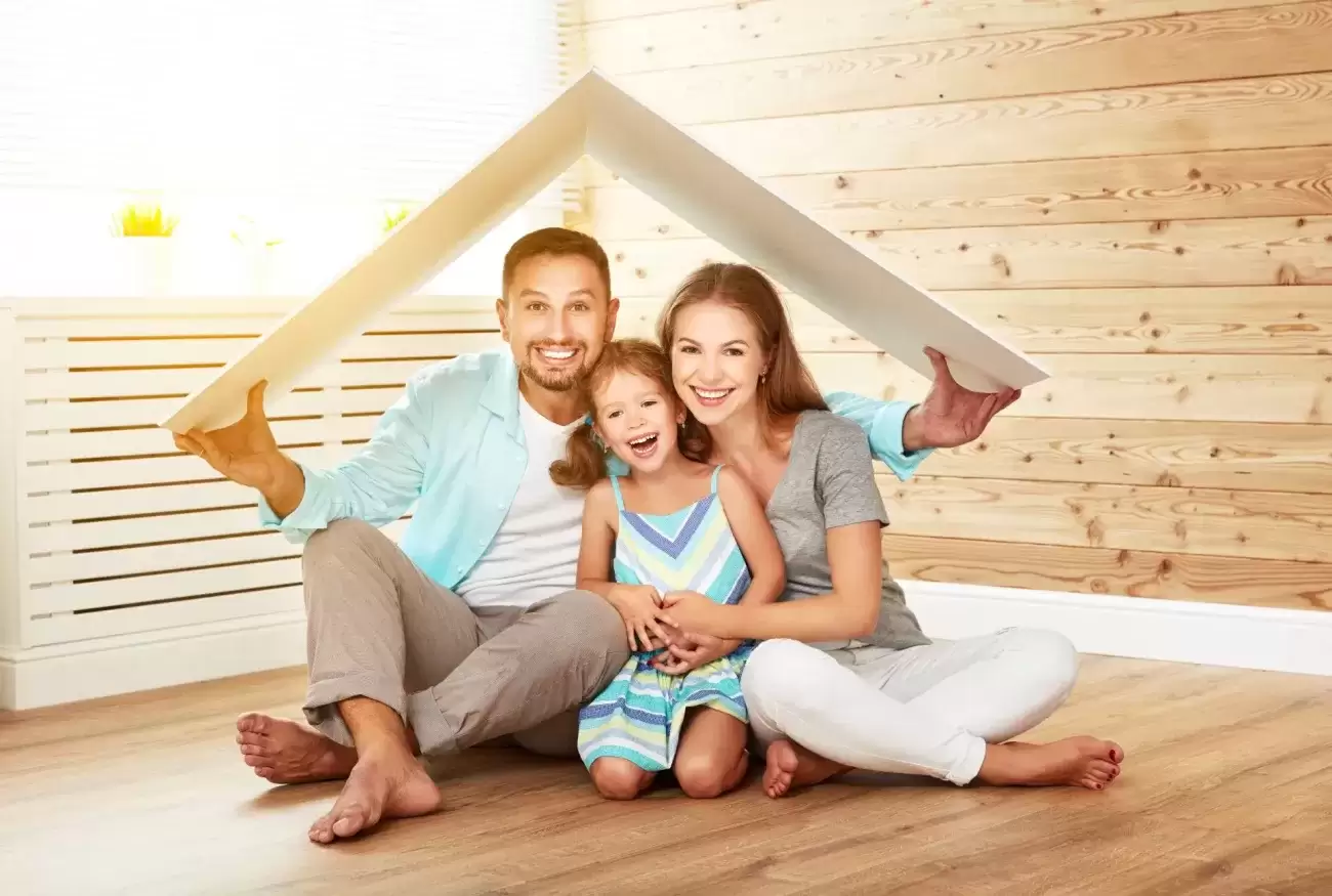 Husband and wife with a child under a toy roof