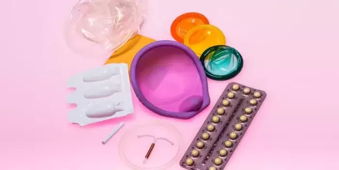 Contraception devices on a pink background